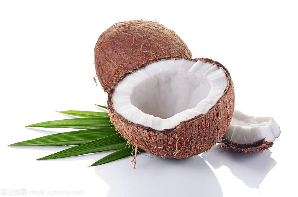 健康的食物。新鮮的椰子與綠色的棕櫚葉